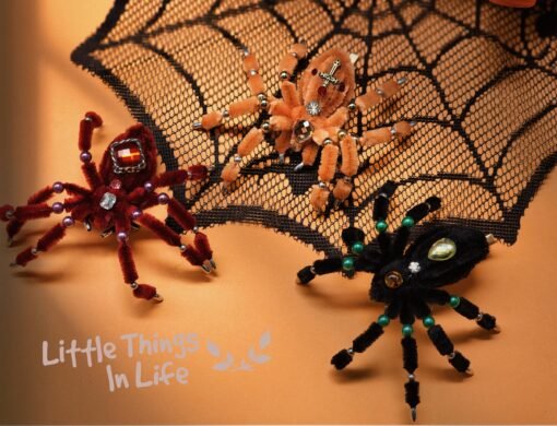 Handmade black spider decoration made with pipe cleaners, featuring crystal bead embellishments in green, amber, and yellow. Perfect for Halloween decor or a unique desk ornament